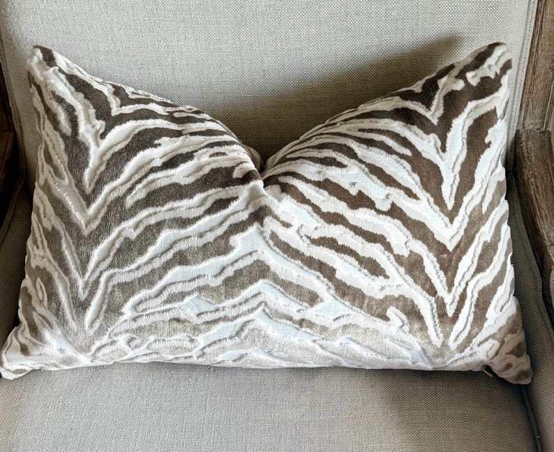 May include: A brown and white zebra patterned throw pillow with a soft, plush texture.