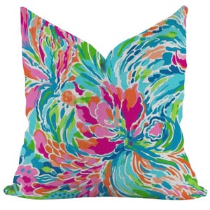 Peut inclure: Un coussin décoratif coloré avec un motif abstrait tourbillonnant dans des tons de rose, orange, bleu, vert et blanc.