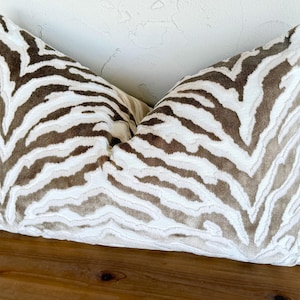 May include: A white and brown zebra print throw pillow with a soft, plush texture.