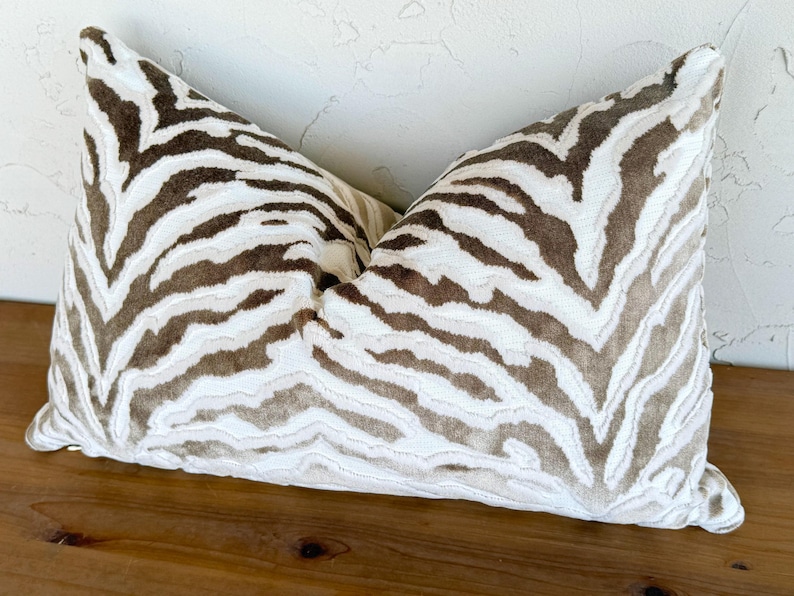 May include: A white and brown zebra print throw pillow with a soft, plush texture.