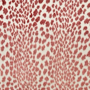 May include: Close-up of a fabric with a repeating pattern of raised, reddish-brown shapes against a cream-colored background. The design resembles a stylized animal print, creating a textured surface. The pattern is densely packed, covering the entire fabric.