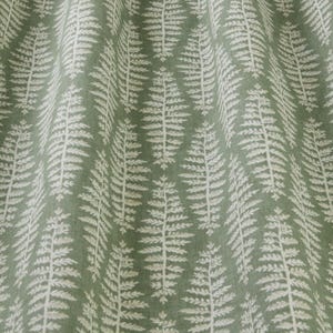 May include: Green fabric with a white fern pattern. The fabric has a subtle texture.