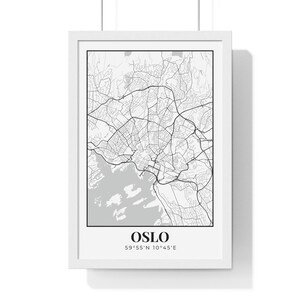 May include: A framed black and white map of Oslo, Norway, with the city name and coordinates displayed at the bottom. The map shows the city's layout, including roads, waterways, and surrounding areas. The frame is white.