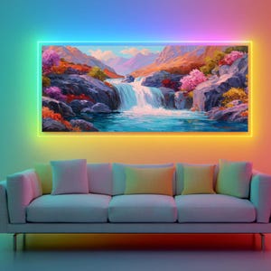 May include: A landscape painting of a waterfall and mountains, framed by a glowing, multi-colored light. The painting hangs above a white sofa with colorful pillows. The artwork features vibrant colors of blue, pink, orange, and green.