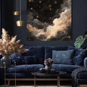 K&ouml;nnte beinhalten: Ein gro&szlig;er, quadratischer Leinwanddruck zeigt eine Nachthimmel-Szene mit dunklen Wolken, goldenen Sternen und einem weichen, leuchtenden Licht. Das Kunstwerk h&auml;ngt &uuml;ber einem marineblauen Samtsofa mit dekorativen Kissen. Der Raum ist mit goldenen Akzenten dekoriert.