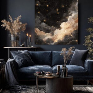K&ouml;nnte beinhalten: Ein gro&szlig;er Leinwandkunstdruck, der eine Nachthimmel-Szene mit Wolken und Sternen zeigt. Das Kunstwerk zeigt einen dunklen Hintergrund mit goldenen Sternen und flauschigen Wolken in Wei&szlig;-, Beige- und Graut&ouml;nen. Der Druck wird &uuml;ber einem blauen Samtsofa angezeigt.