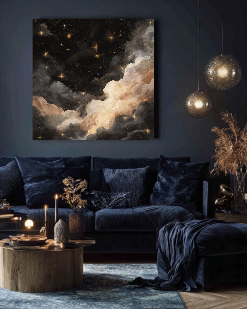 K&ouml;nnte beinhalten: Ein gro&szlig;es quadratisches Leinwandkunstwerk, das einen Nachthimmel mit Wolken und Sternen darstellt. Das Kunstwerk zeigt einen dunklen Hintergrund mit flauschigen, hellfarbigen Wolken und funkelnden goldenen Sternen. Der Raum hat ein dunkelblaues Sofa, einen Couchtisch und dekorative Beleuchtung.
