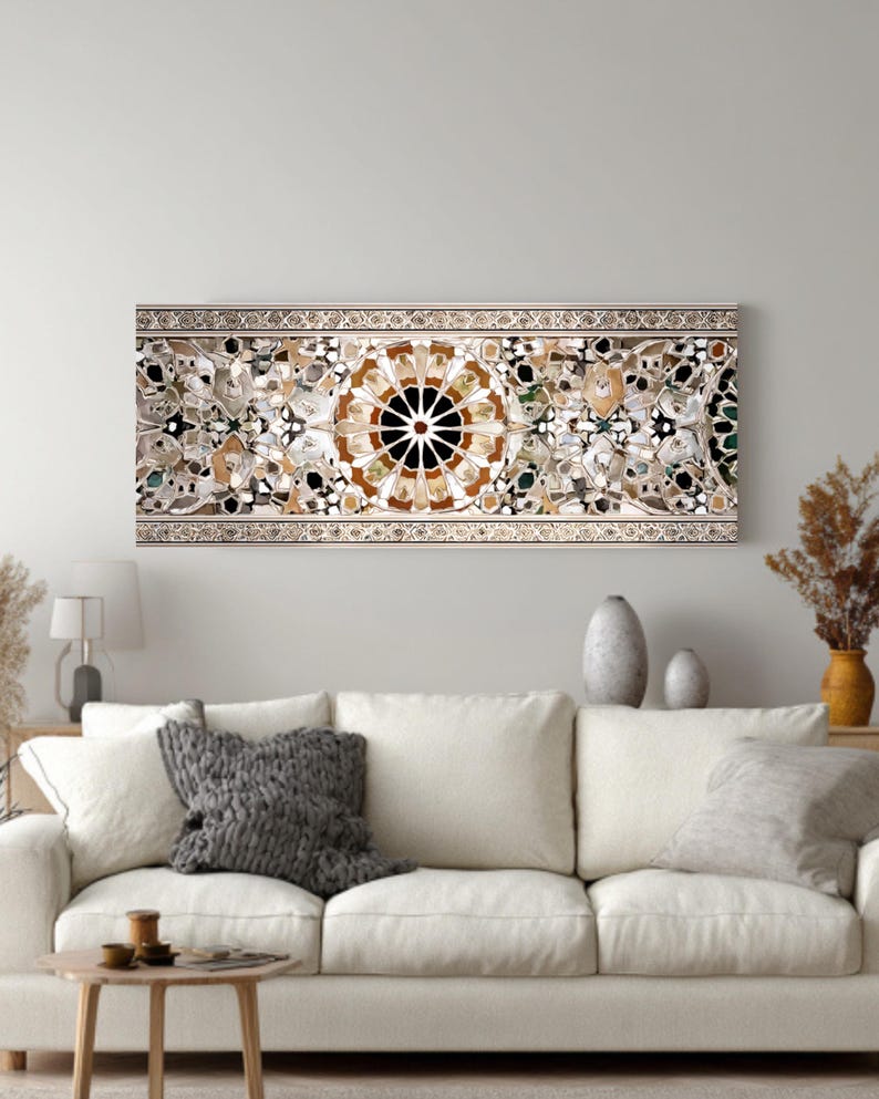 Op de afbeelding: Een lang, rechthoekig wandkunstwerk met een gedetailleerd moza&iuml;ekontwerp. Het moza&iuml;ek heeft een centraal cirkelvormig patroon met bruine, zwarte en witte elementen, omgeven door bloem- en geometrische vormen. Het kunstwerk is omlijst met een decoratieve rand.
