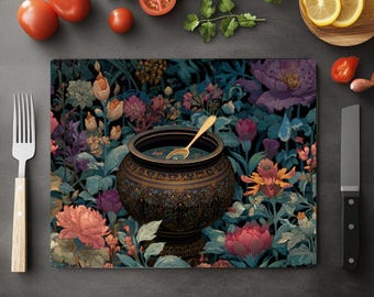 Könnte beinhalten: Ein dekoratives Schneidebrett mit floralem Design, dunklem Hintergrund und bunten Blumen. Ein dunkler Topf mit einem goldenen Löffel darin befindet sich in der Mitte. Tomaten, Zitronenscheiben und ein Messer sind ebenfalls sichtbar.