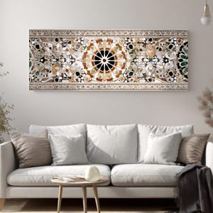 Op de afbeelding: Een rechthoekig wandkunstwerk met een moza&iuml;ekontwerp. Het moza&iuml;ek heeft een centraal cirkelvormig patroon met een zwart centrum en stralende lijnen, omgeven door ingewikkelde bloemen en geometrische elementen in verschillende kleuren.