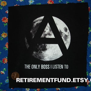 Op de afbeelding: Zwart-witte strijkpatch met een gestileerde letter A en de tekst "The Only Boss I Listen To".