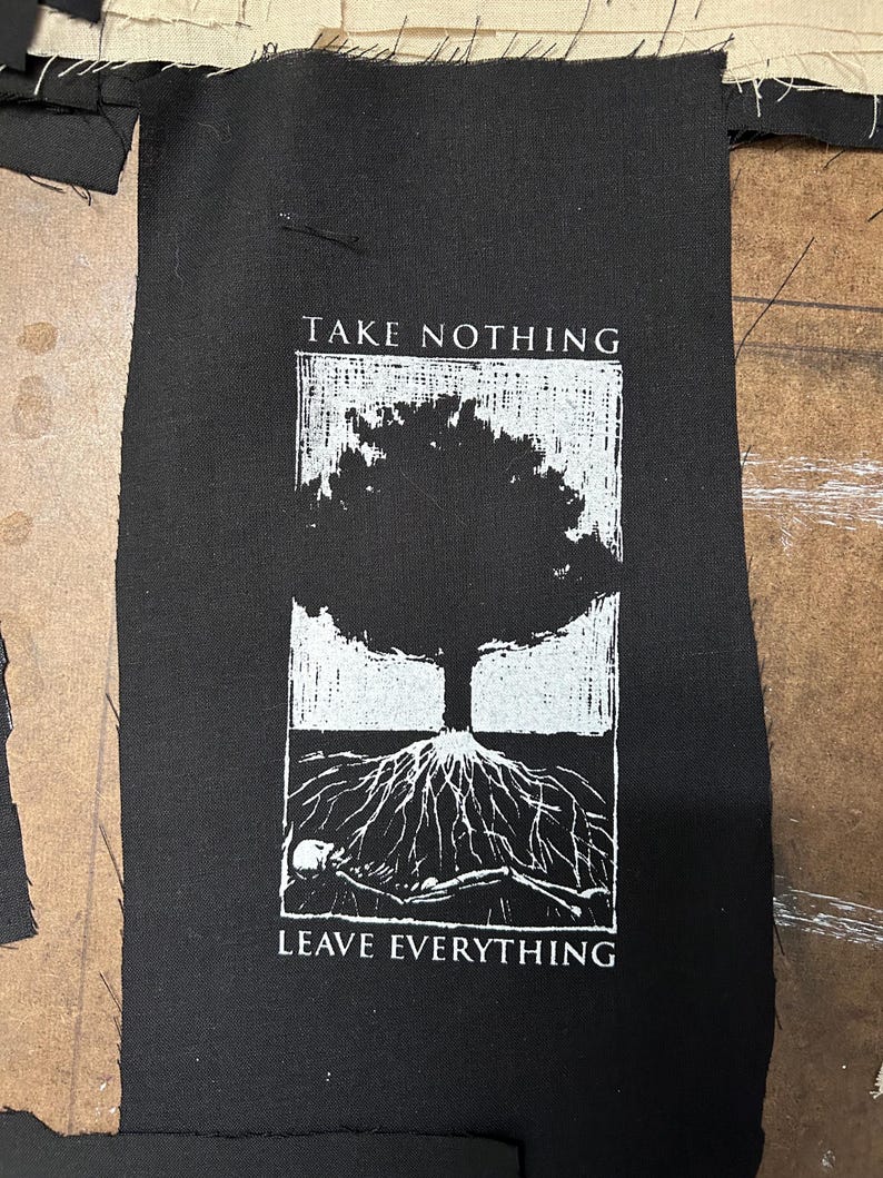 May include: Black fabric patch with a white graphic of a tree with exposed roots and a skeleton. The text "TAKE NOTHING" is above the tree, and "LEAVE EVERYTHING" is below.