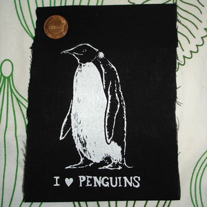 Może przedstawiać: Czarna łatka z tkaniny z białą ilustracją pingwina i tekstem "I ♥ PENGUINS". Łatka zawiera również stronę internetową "RETIREMENTFUND.ETSY.COM".
