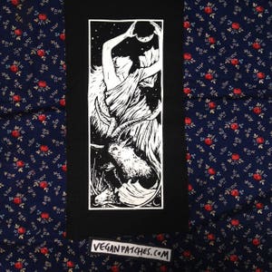 May include: Black and white iron-on patch featuring a woman with a goat and a crescent moon. The patch has the text "veganpatches.com" at the bottom.