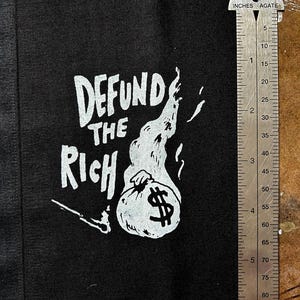 DEFUND THE RICH Aufnäher auf der Nase und, naja, mehr als mit diesem einen Patch kann ich nicht hinter eine Botschaft bekommen