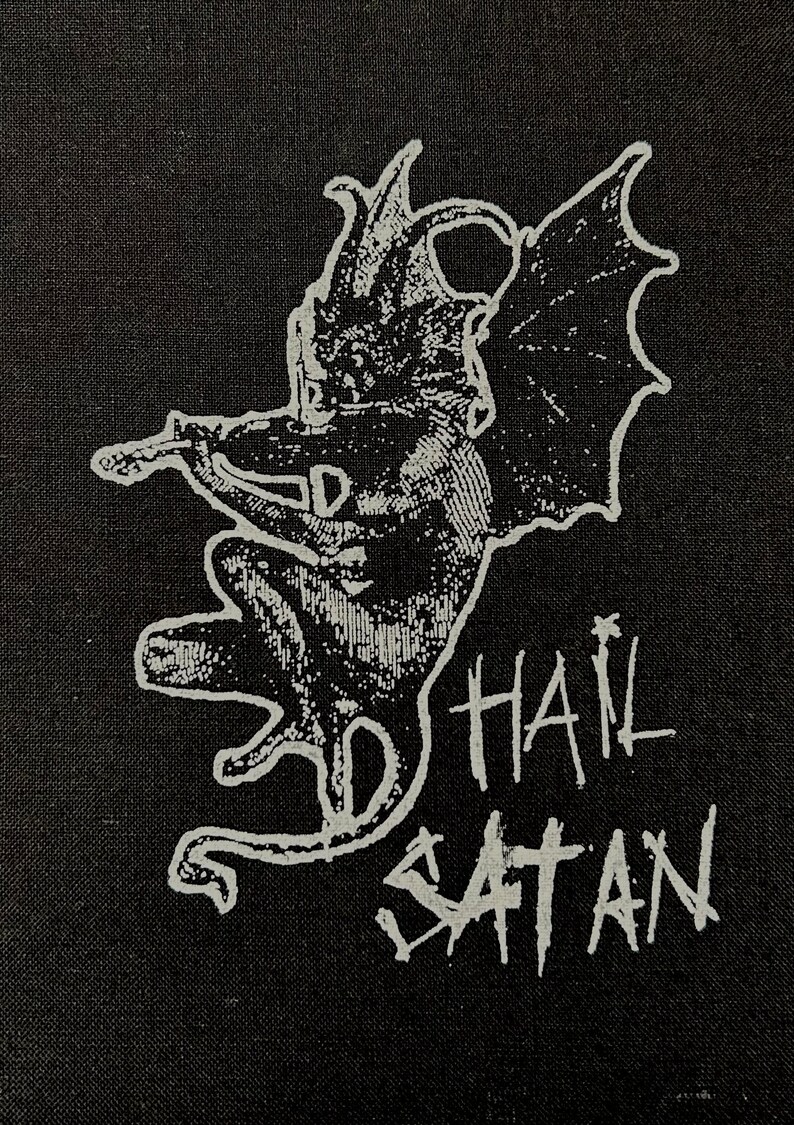 May include: Black and white patch featuring a winged demon figure and the text "Hail Satan" in white.
