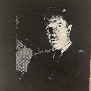 Könnte beinhalten: Schwarz-weißer Stoffaufnäher mit einem Halbtonbild eines Mannes in Anzug und Krawatte. Das Bild ist ein Porträt eines Mannes mit Schnurrbart. Der Aufnäher ist quadratisch und aus Stoff.