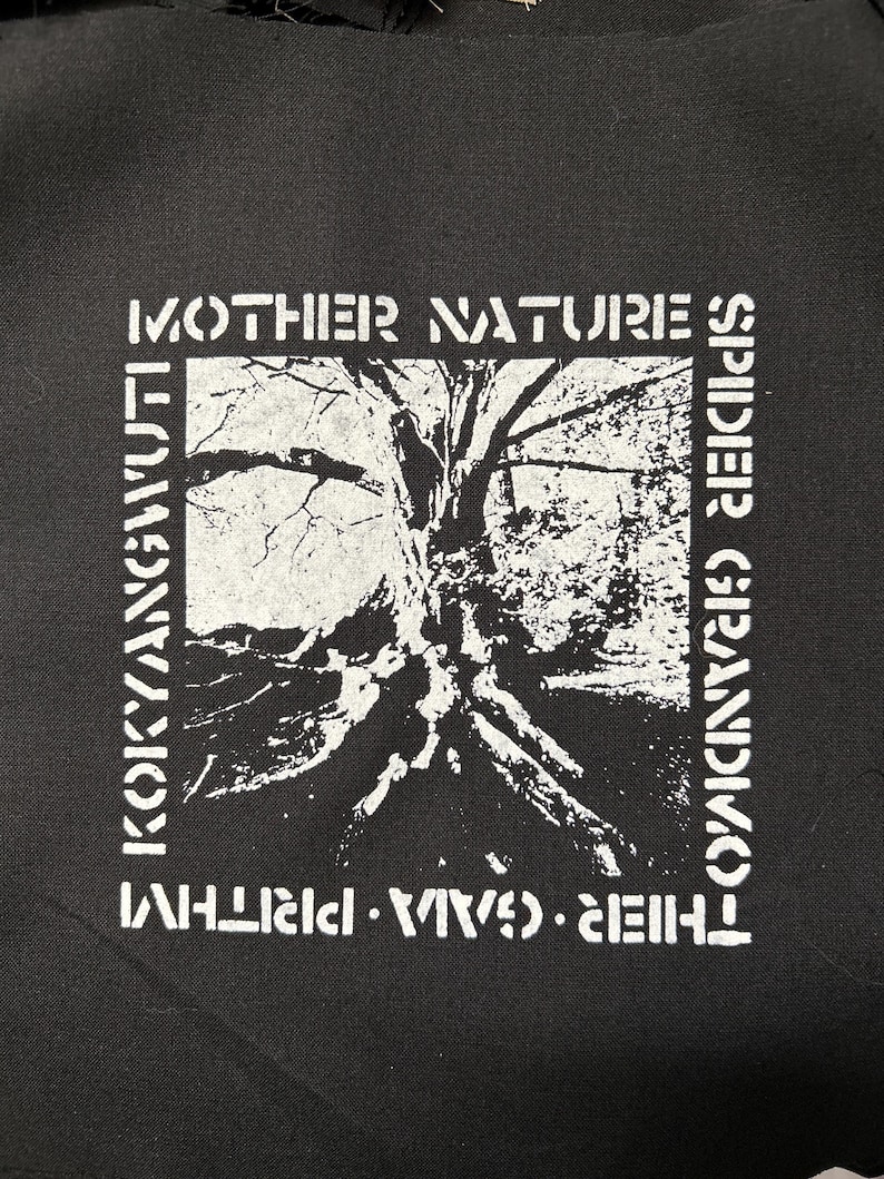 May include: Black and white patch with the text "MOTHER NATURE'S SPIDER", "THEIR. WAVES. WHIRL", and "KOKYANGWUTI" surrounding a black and white image of a tree with roots.