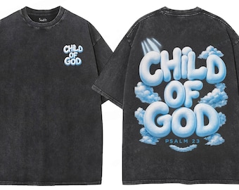 May include: A wash black short-sleeve t-shirt featuring a small blue bubble-letter graphic on the front chest that reads Child of God. The back displays a large blue bubble-letter graphic reading Child of God with clouds and the text Psalm 23.