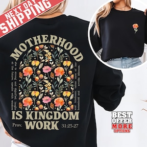 May include: Black sweatshirt with floral design and text "MOTHERHOOD IS KINGDOM WORK" with a Bible verse reference. The design includes orange, pink, and yellow flowers. A smaller version of the floral design is on the front. "NEXT DAY SHIPPING" is in the top left corner.