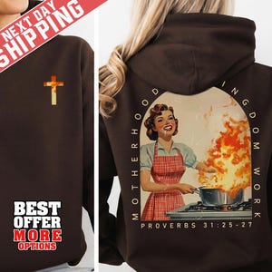 Puede incluir: Una sudadera con capucha marrón con una cruz dorada en la parte delantera. La parte trasera presenta una ilustración de estilo vintage de una mujer cocinando con llamas, las palabras "Motherhood Kingdom Work" y "Proverbios 31:25-27".