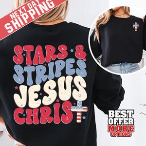 Könnte beinhalten: Schwarzes Sweatshirt mit dem Text "STARS & STRIPES JESUS CHRIST" in Rot, Weiß und Blau. Ein kleines Kreuz mit dem Design der amerikanischen Flagge befindet sich auf der oberen rechten Brust. Das Sweatshirt hat einen Rundhalsausschnitt.