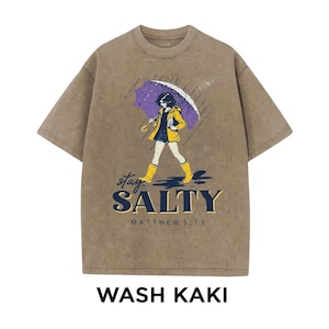May include: Khaki-colored t-shirt with a graphic of a person walking in the rain under a purple umbrella. The text "stay SALTY" and "MATTHEW 5:13" are below the graphic. The words "WASH KAKI" are at the bottom.