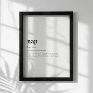 May include: A black framed print featuring the word "nap" in a bold font. The definition below reads "a short visit to heaven, tragically brief, criminally underrated, and always interrupted at the best part."