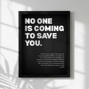Peut inclure: Impression encadrée en noir avec le texte blanc "NO ONE IS COMING TO SAVE YOU." Un paragraphe de texte est situé en dessous. L'impression est affichée sur un mur blanc.
