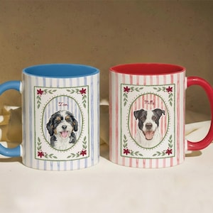 Puede incluir: Dos tazas de cer&aacute;mica con retratos de perros. La taza izquierda tiene un asa e interior azul con rayas azules y el retrato de un perro llamado Tom. La taza derecha tiene un asa e interior rojo con rayas rojas y el retrato de un perro llamado Milly.
