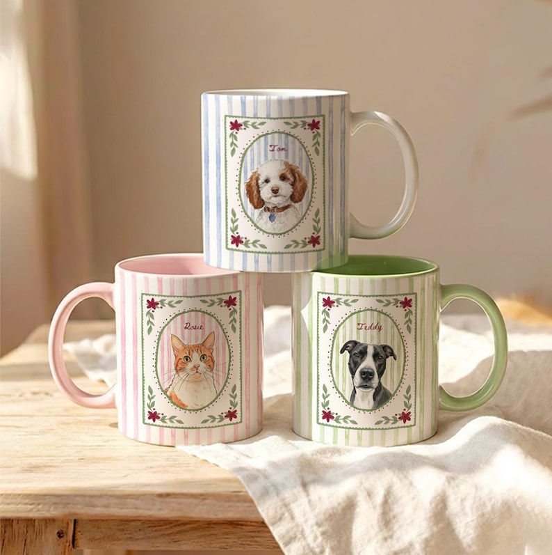 Puede incluir: Tres tazas de cer&aacute;mica con rayas verticales y retratos ovalados centrales de mascotas. La taza superior tiene rayas azules y un perro llamado Tom. La taza inferior izquierda tiene rayas rosas y un gato llamado Rosie. La taza inferior derecha tiene rayas verdes y un perro llamado Teddy.
