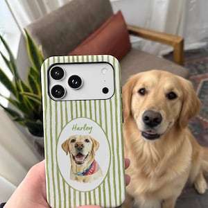 Op de afbeelding: Een smartphonehoesje met een verticaal gestreept patroon in olijfgroen en wit. In het midden bevindt zich een ovaal kader met een aquarelillustratie van een golden retriever met een blauwe bandana, met daarboven de naam Harley gedrukt.