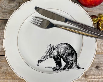 Porzellanteller „Erdferkel“, Vintagegeschirr mit Goldrand und handgedrucktem Motiv;