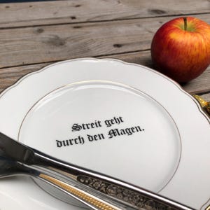 Saying plate &quot;The way to a fight is through the stomach&quot;, approx. 20 cm; cheeky saying on grandma&#39;s gold-rimmed plate - for the table, for the wall, as a gift...