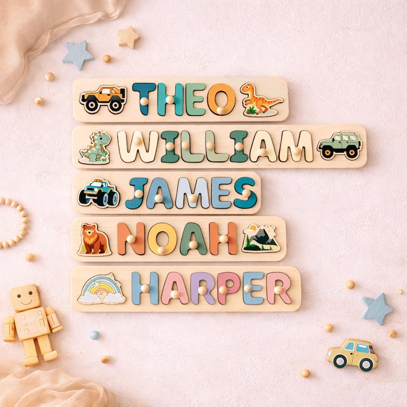 K&ouml;nnte beinhalten: F&uuml;nf Holz-Namenspuzzles mit den Namen THEO, WILLIAM, JAMES, NOAH und HARPER. Jedes Puzzle enth&auml;lt bunte, ausgeschnittene Buchstaben mit kleinen Holzkn&ouml;pfen, verziert mit Illustrationen von Fahrzeugen, Dinosauriern, einem B&auml;ren, Bergen und einem Regenbogen.