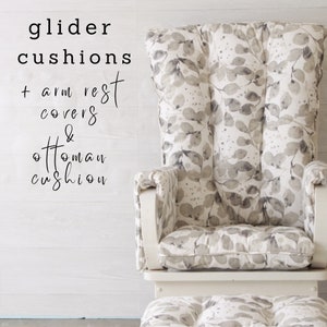 May include: White glider with a gray and white leaf patterned cushion, arm rests, and ottoman. The text "glider cushions + arm rest covers & ottoman cushion" is written on the wall behind the glider.