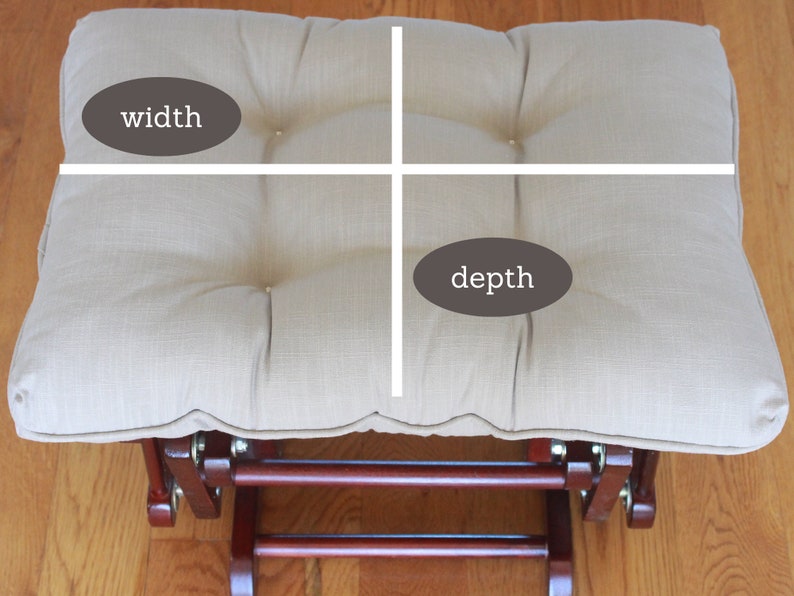 May include: Beige fabric ottoman with a tufted top and a wooden base. The ottoman is 20 inches wide and 16 inches deep.