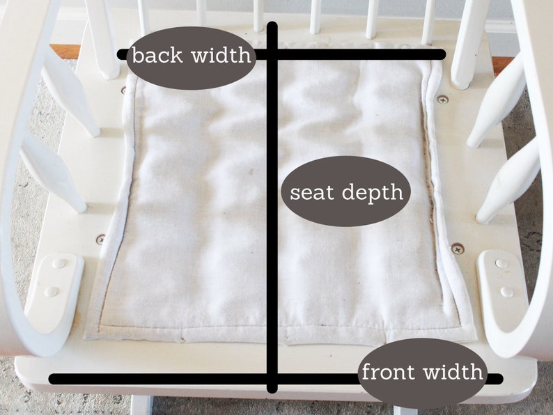 Puede incluir: Silla mecedora blanca con un coj&iacute;n de asiento de tela blanca. El coj&iacute;n del asiento est&aacute; etiquetado con medidas para el ancho del respaldo, la profundidad del asiento y el ancho del frente.
