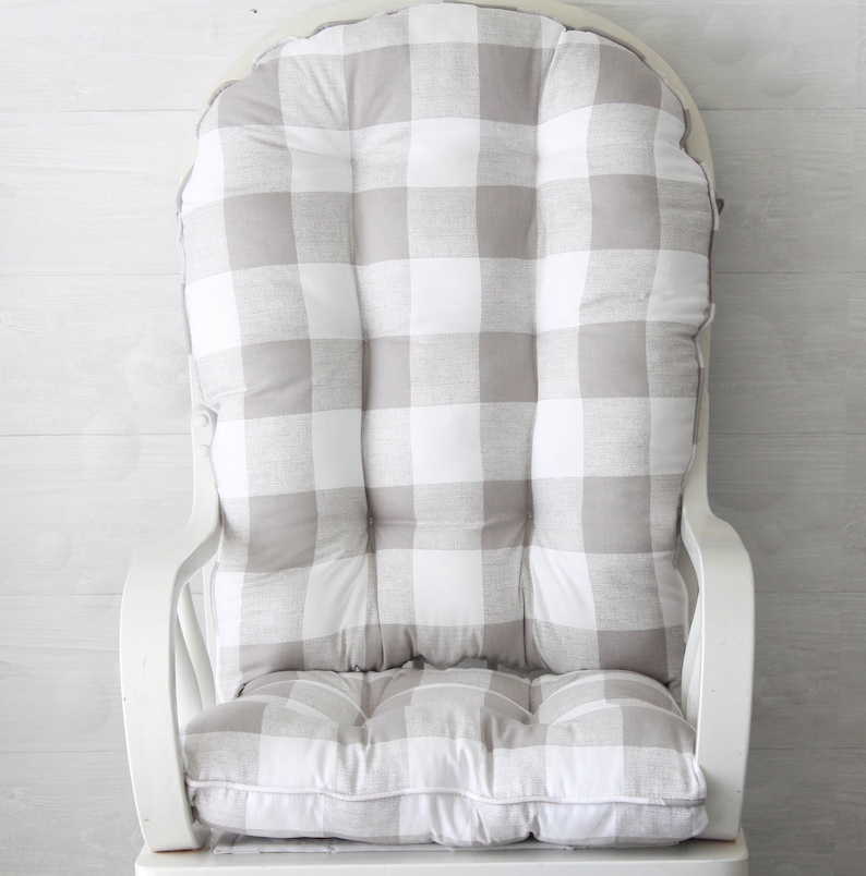 Puede incluir: Un coj&iacute;n para mecedora de gingham blanco y gris con dise&ntilde;o capiton&eacute;.