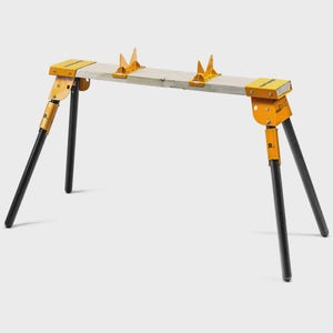 Peut inclure: Un tréteau portable composé d'une poutre en bois clair soutenue par quatre pieds tubulaires noirs. La structure comprend des supports métalliques jaunes aux extrémités et deux supports en V jaunes réglables fixés sur la poutre.