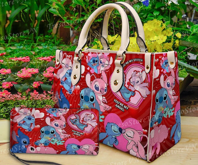Puede incluir: Un bolso tote rojo y una cartera a juego con un dise&ntilde;o de personaje de dibujos animados. El bolso tiene asas y detalles en color crema. El dise&ntilde;o incluye corazones y el texto "You're My Angel" y "You're My Stitch".
