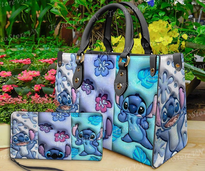 K&ouml;nnte beinhalten: Ein blau-wei&szlig;es Shopper-Taschen- und passendes Geldb&ouml;rsen-Set. Die Tasche hat ein Cartoon-Charakter-Design mit blauen und rosa floralen Akzenten. Die Geldb&ouml;rse hat eine Handschlaufe. Das Set ist aus Kunstleder.