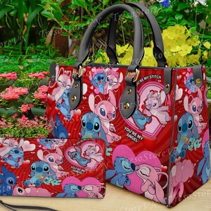 Puede incluir: Un bolso de mano rojo y una cartera a juego con un patr&oacute;n repetido de personajes de dibujos animados, corazones y las frases "You're My Angel" y "You're My Stitch". El bolso tiene asas negras y herrajes dorados.