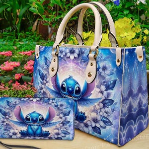 May include: A blue handbag and matching wallet featuring a cartoon character design. The handbag has cream-colored handles and a floral pattern with the character. The wallet has a wrist strap and a similar design.