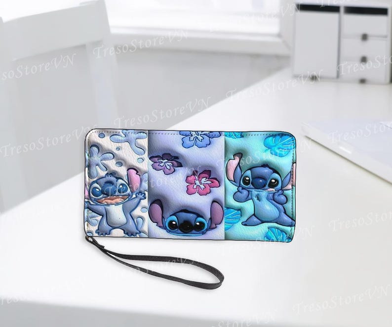 K&ouml;nnte beinhalten: Ein dreifach gefaltetes Portemonnaie mit einer schwarzen Handschlaufe, das die Figur Stitch aus Lilo & Stitch zeigt. Das Portemonnaie ist in drei Abschnitte unterteilt, jeder mit einem anderen Stitch-Design und floralen Mustern in Blau, Rosa und Wei&szlig;.