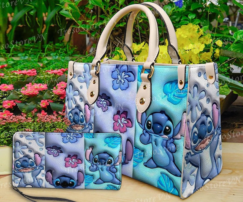 K&ouml;nnte beinhalten: Ein hellblaues Handtaschen- und passendes Geldb&ouml;rsen-Set mit einem Cartoon-Charakter-Design. Die Handtasche hat cremefarbene Griffe und ein Blumenmuster. Die Geldb&ouml;rse hat eine Handschlaufe. Das Set ist mit blauen und rosa Blumen verziert.