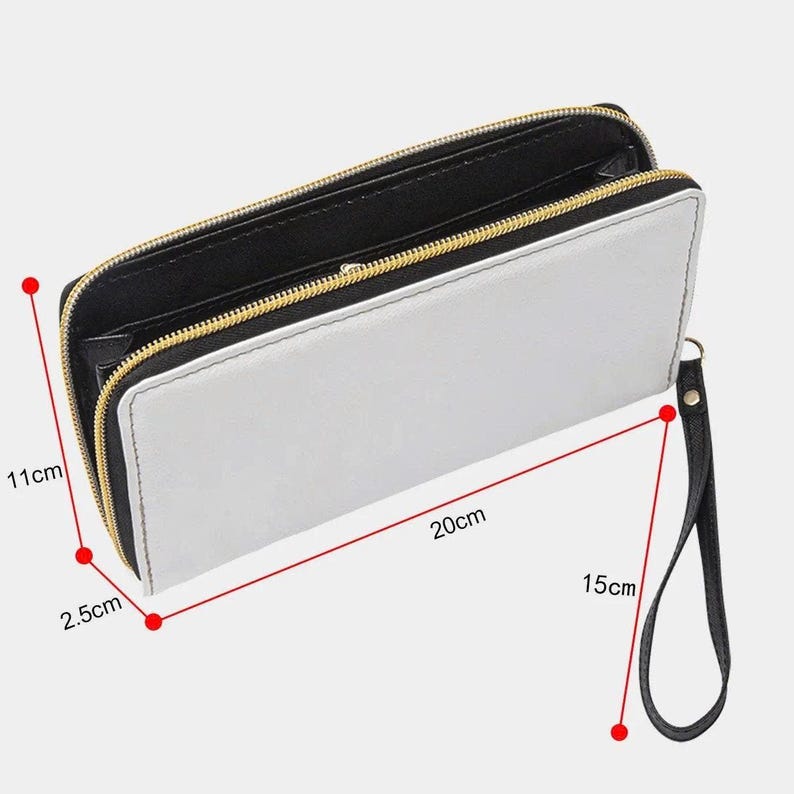 Puede incluir: Una cartera blanca con interior negro y cremallera dorada. La cartera mide 20 cm de largo, 11 cm de alto y 2,5 cm de grosor. Tiene una correa de mu&ntilde;eca negra de 15 cm de largo.
