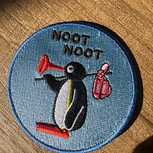 May include: A white ceramic mug with a black handle and the text "But First, Coffee" in a bold, black font. The mug is set against a neutral background, highlighting its simple design.