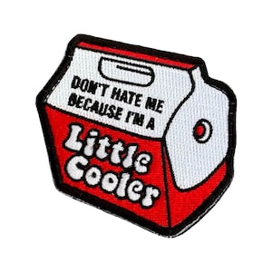 May include: Embroidered patch in the shape of a red and white cooler. The patch reads "DON'T HATE ME BECAUSE I'M A Little Cooler" in black and red lettering. The patch has a black border.