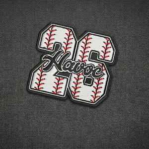 May include: Embroidered patch featuring the number "26" in a baseball design. The patch has a white background with red stitching, mimicking a baseball. The word "Havoc" is embroidered in black script across the center.